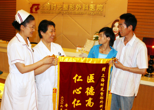 小鲁父女展开绣有“妙手扶桑梓，高医攀新峰”的锦旗，感谢社会各界爱心人士的关心和援助。